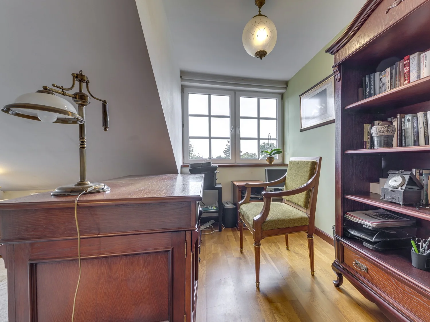 Korytarz na piętrze z balustradą i obrazami