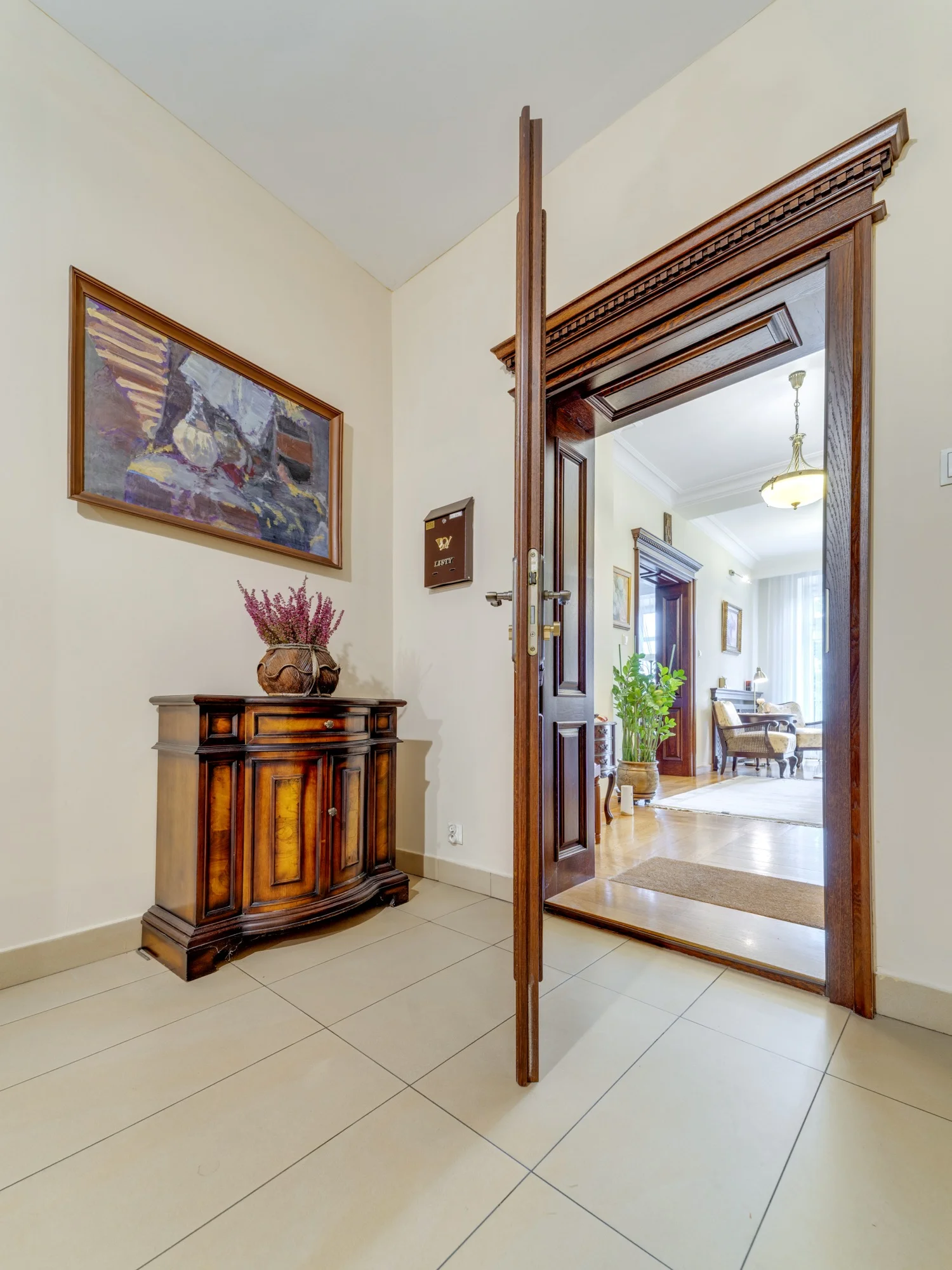 Wejście do apartamentu z zabytkową komodą